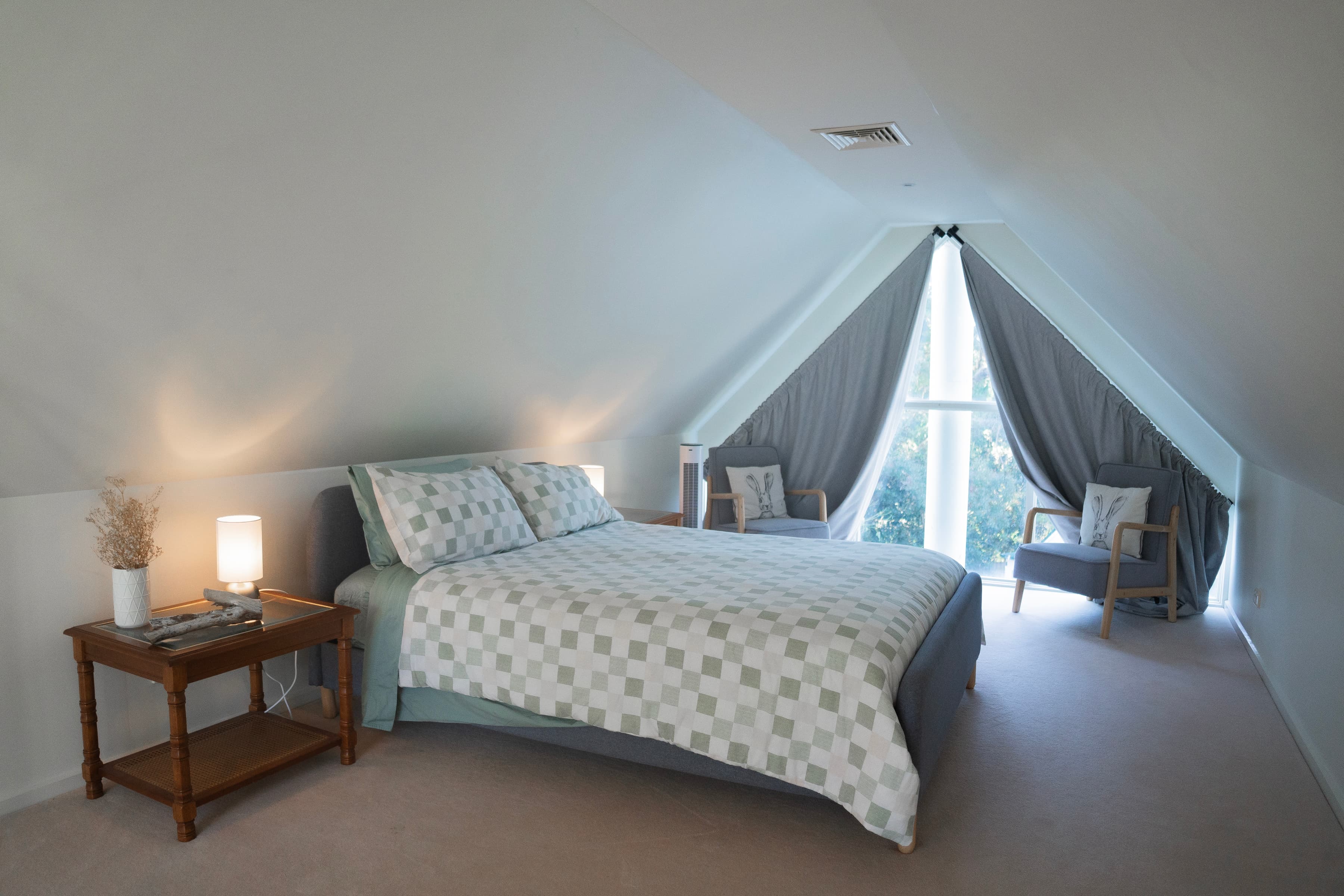 The Studio cozy attic bedroom with checkered bedding and skylights